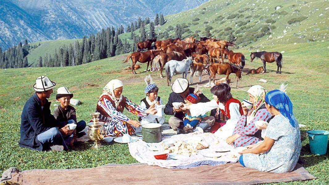 большая киргизская семья обедает на пастбище среди гор большая киргизская семья обедает на пастбище среди гор