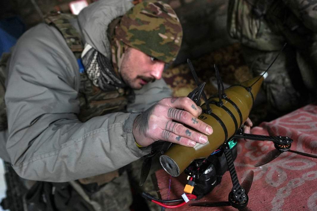 Военный ВСУ устанавливает взрывное устройство на дрон 