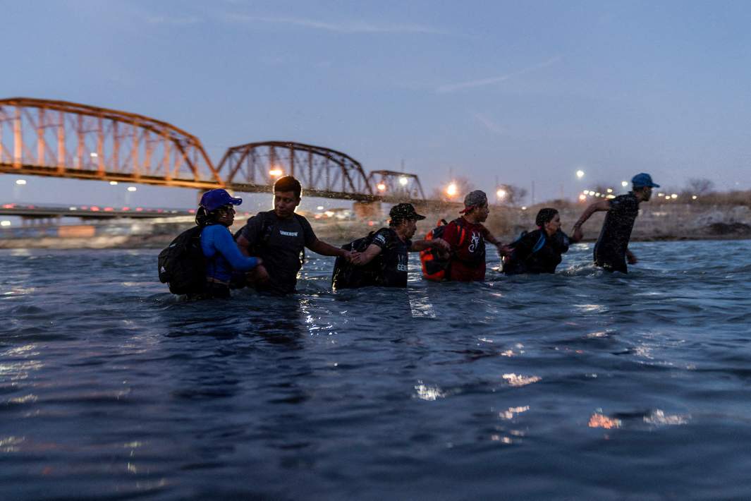 Мигранты переходят вброд реку Рио-Гранде на границе США и Мексики