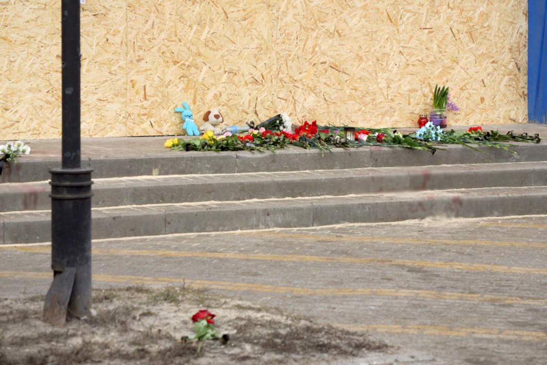 Стихийный мемориал у здания, поврежденного в результате обстрела города со стороны ВСУ