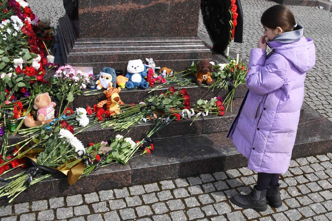 Девочка возлагает цветы к стеле «Владивосток — город воинской славы» в день общенационального траура по погибшим в результате теракта в подмосковном «Крокус Сити Холле»