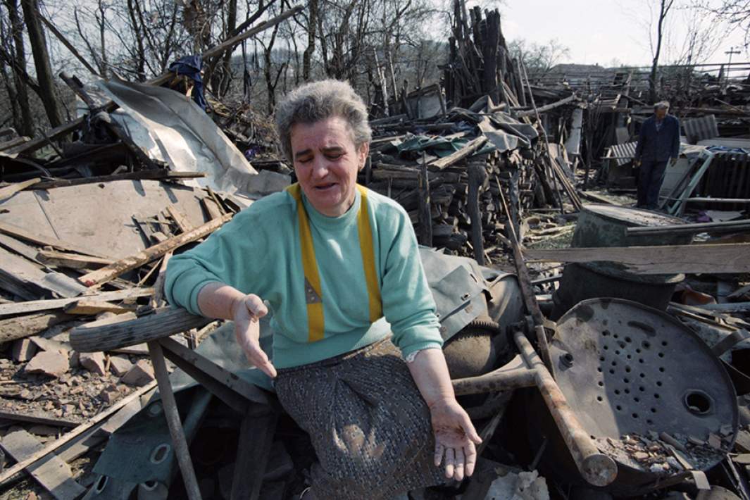 Жительница города Чачак Раденко Пртенякович на развалинах своего дома после бомбардировки. 5 апреля 1999 года