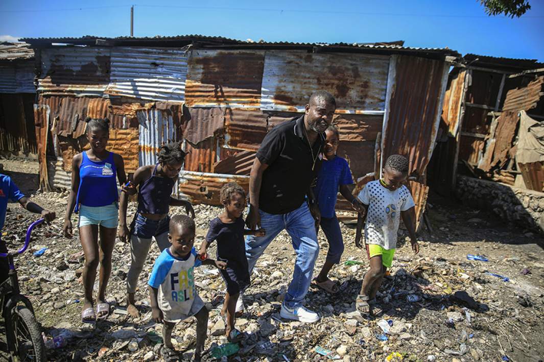 Джимми Шеризье гуляет с детьми во время посещения района Ла-Салин в Порт-о-Пренсе, Гаити, 24 января 2023 года
