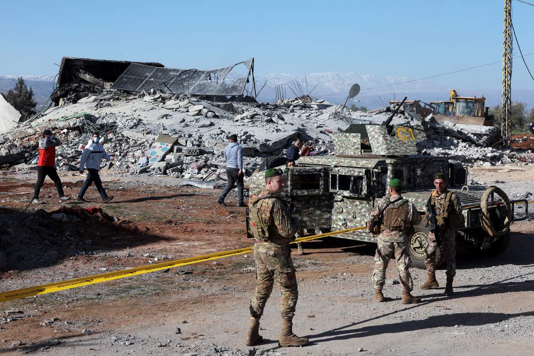 Солдаты ливанской армии охраняют объект, пострадавший от удара после того, как израильские самолеты во вторник второй день наносили удары по ливанской долине Бекаа, по данным источников в службах безопасности, в Сараане, Ливан, 12 марта 2024 года.
