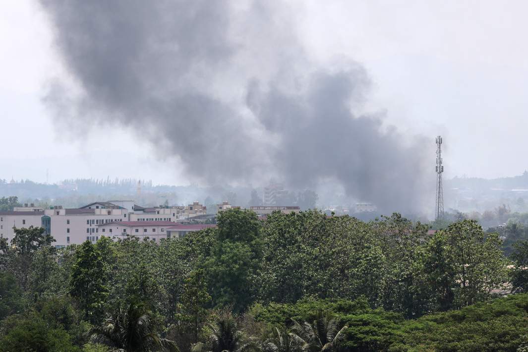 Дым от пожаров, возникших на улицах Мьявади в результате боев между повстанцами и правительственными войсками