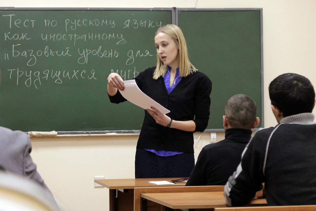 Экзаменатор зачитывает задания перед началом тестирования по русскому языку для трудовых мигрантов