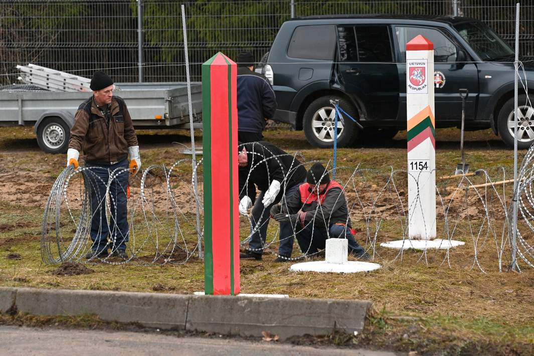 Рабочие устанавливают проволочное заграждение на контрольно-пропускном пункте «Лаворишкес» на белорусско-литовской границе