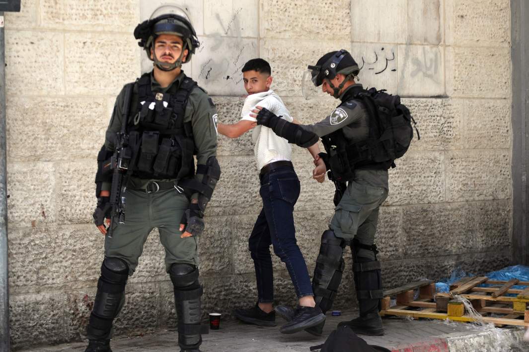 Израильские солдаты задерживают палестинца на одной из улиц Хеврона