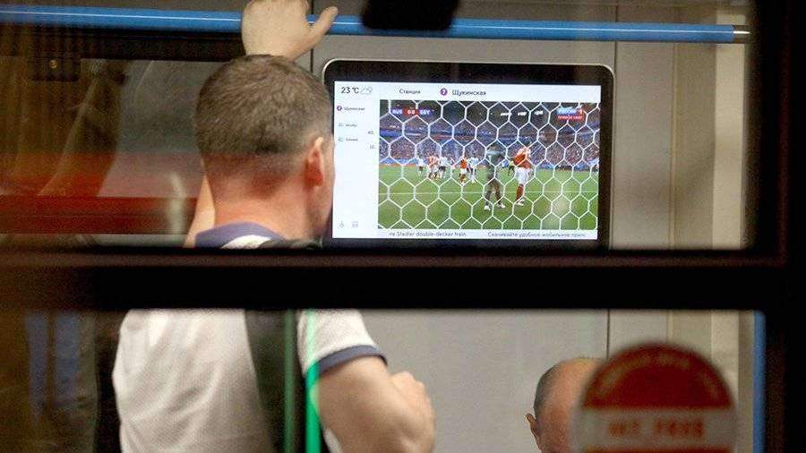 человек смотрит футбол на смартфоне в метро