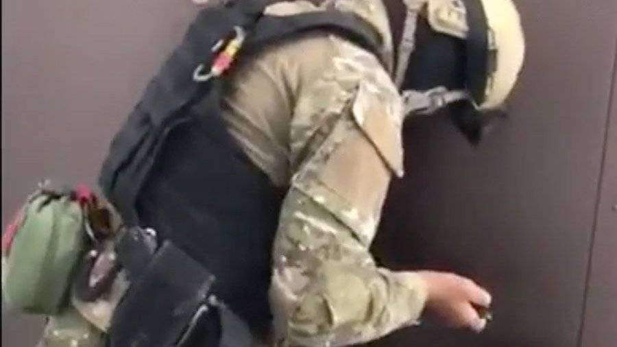 Сотрудник спецслужб вскрывает дверь
