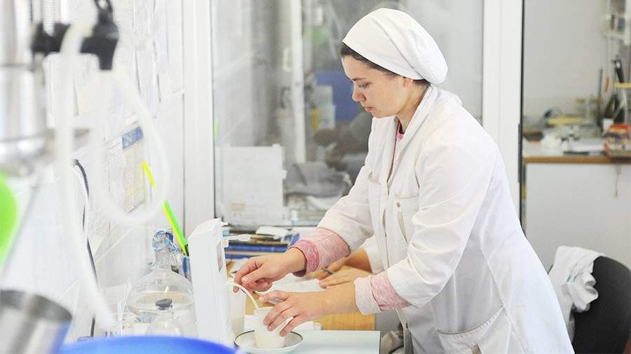 Специалист исследует молоко в лаборатории сыродельного завода