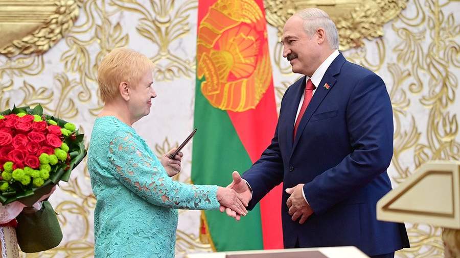Председатель Центральной комиссии Белоруссии по выборам и проведению республиканских референдумов Лидия Ермошина вручает Александру Лукашенко удостоверение президента Белоруссии во время церемонии вступления в должность во Дворце Независимости