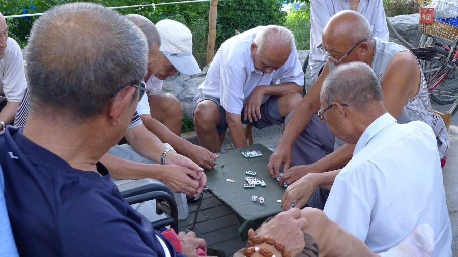 Жители Китая старшего возраста играют в домино