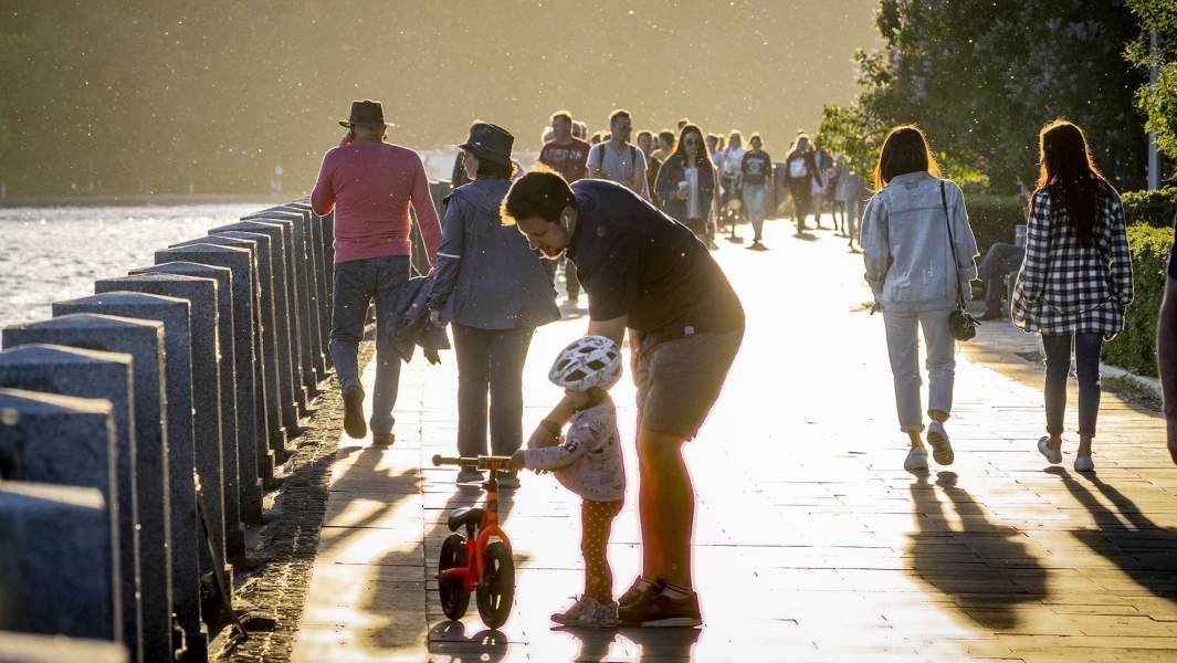 люди гуляют по набережной в Москве