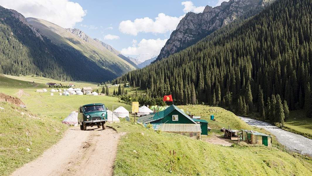 фургон едет через селение неподалеку от КАракола в Киргизии