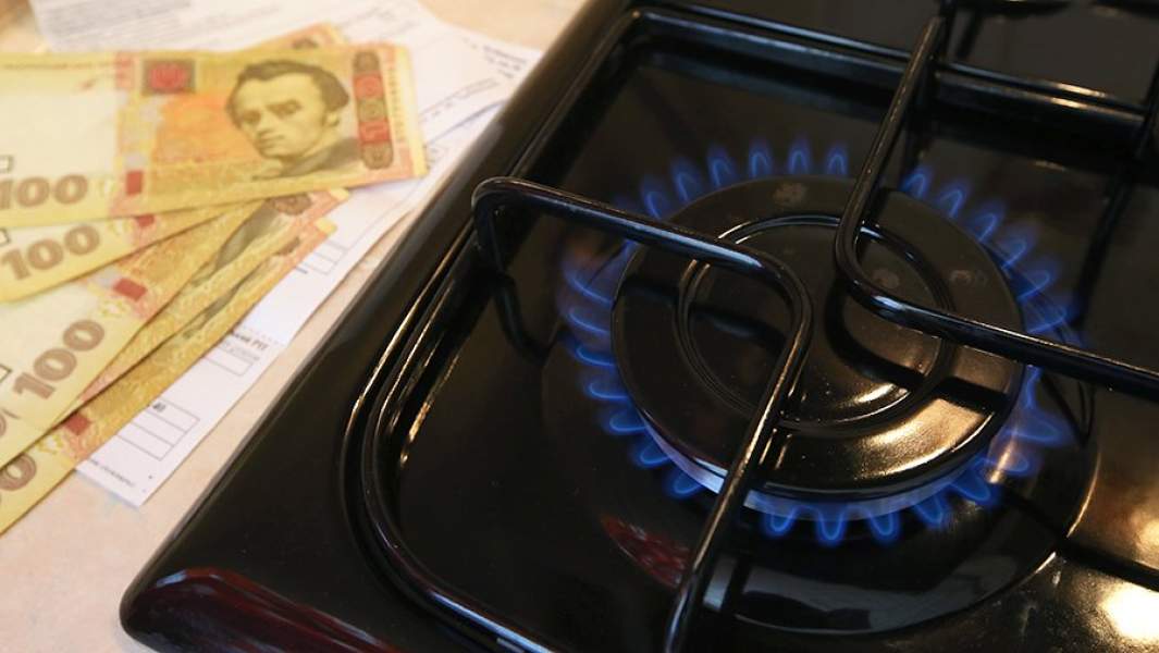 Горящая газовая конфорка и денежные купюры Украины