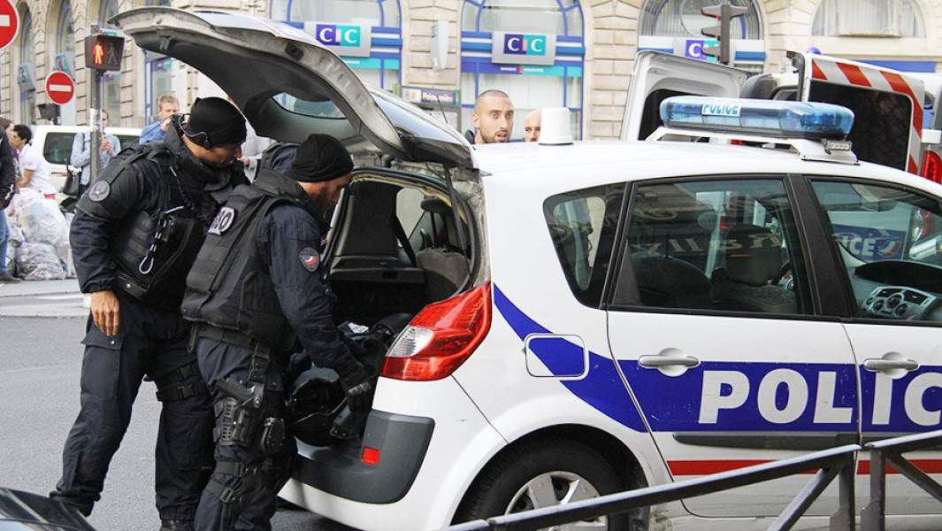 Полицейские открывают багажник патрульного автомобиля