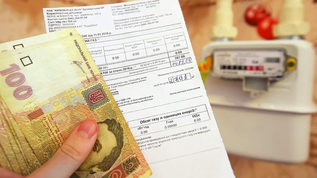 Денежные купюры Украины и квитанция за оплату коммунальных услуг