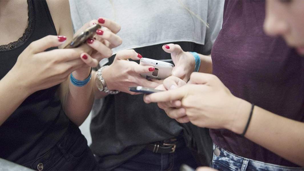 Три девушки со смартфонами в руках