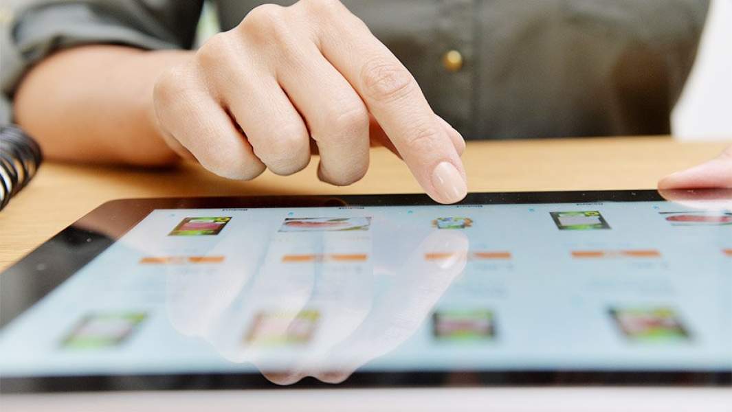 Женщина выбирает товар в интернет-магазине на планшете