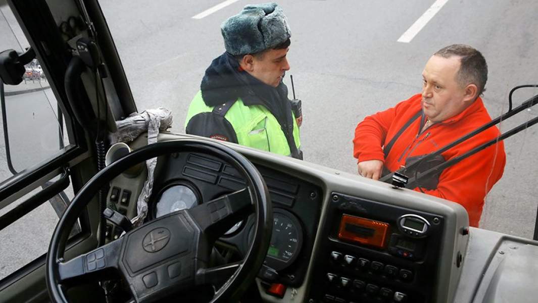 Сотрудник ДПС проверяет документы у водителя маршрутного автобуса