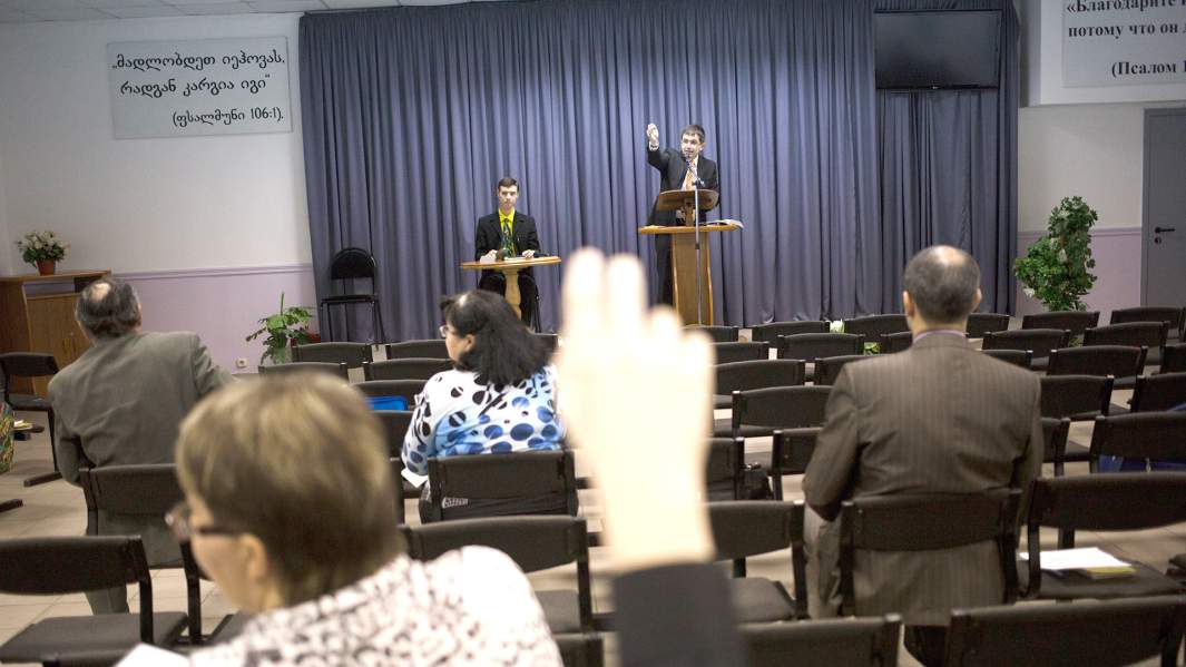 Члены организации «Свидетели Иеговы» обсуждают Библию во время встречи