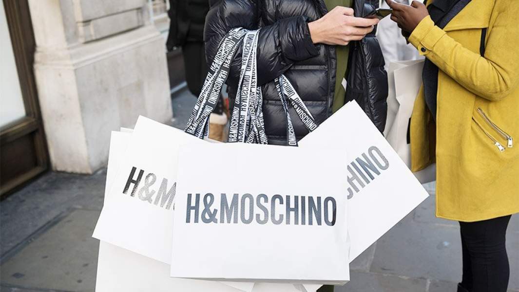 Люди на улице с пакетами H&Moschino