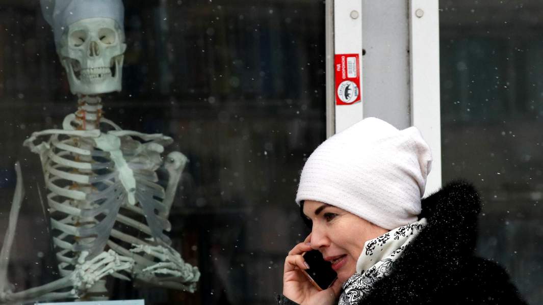 Женщина проходит мимо витрины медицинского магазина в Киеве