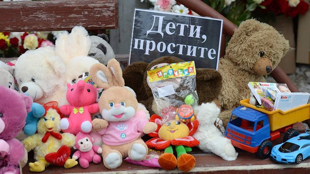 Цветы и мягкие игрушки возле здания торгового центра «Зимняя вишня» в Кемерово