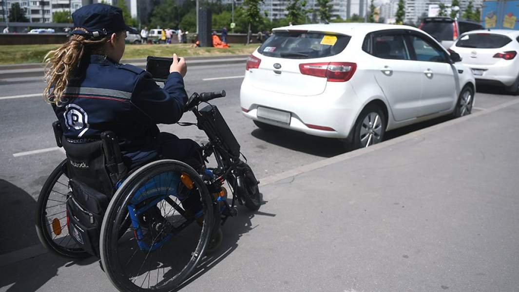 Инспектор Администрации московского парковочного пространства следит за соблюдением оплаты и правил парковки для инвалидов