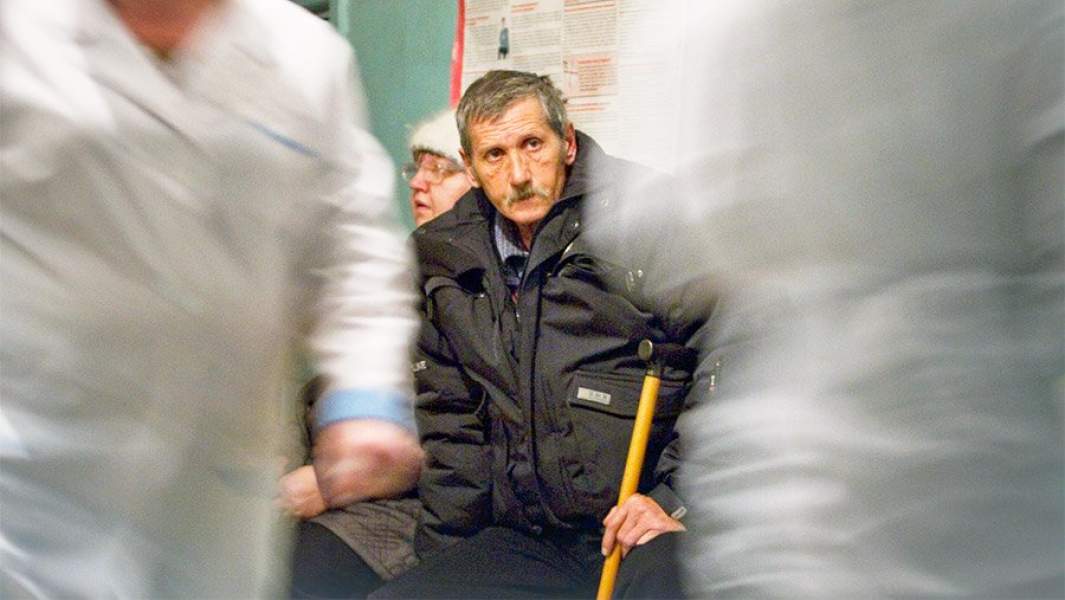 Мужчина на костылях в коридоре больницы