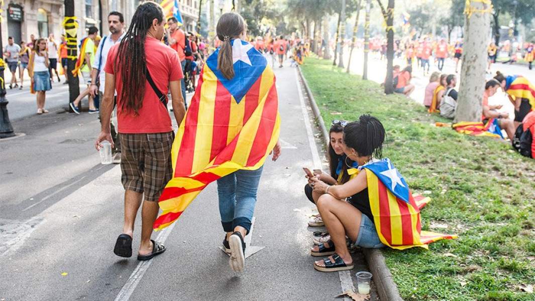 Молодые люди с флагами Каталонии на плечах