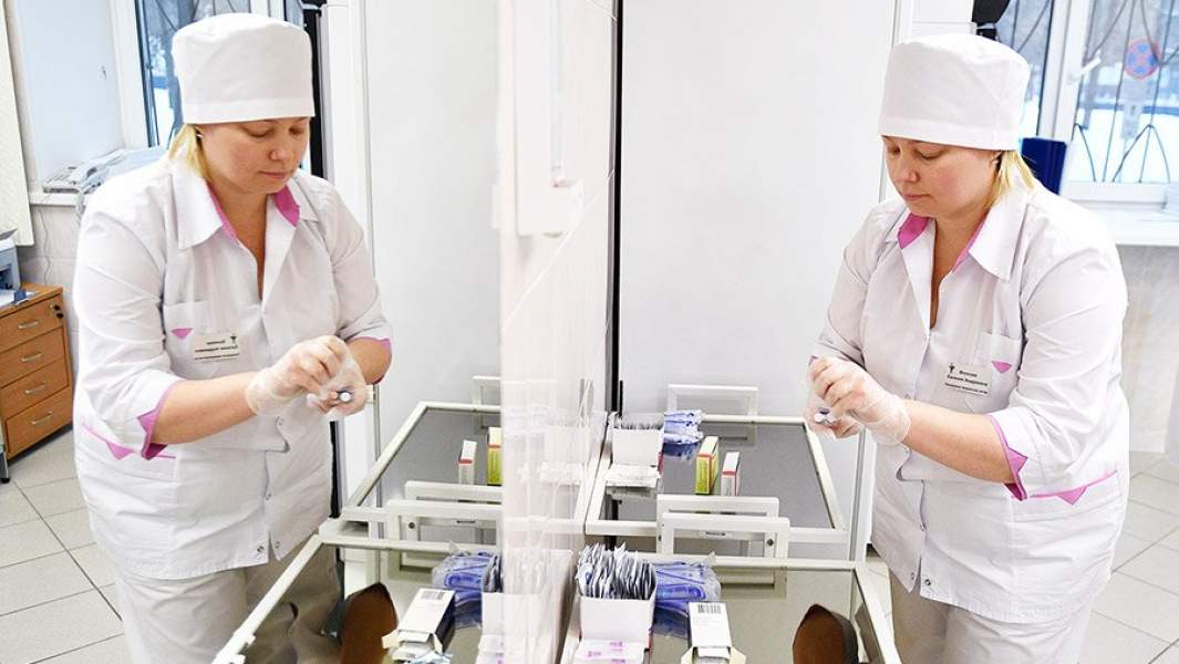 Медсестра готовит шприц для прививки