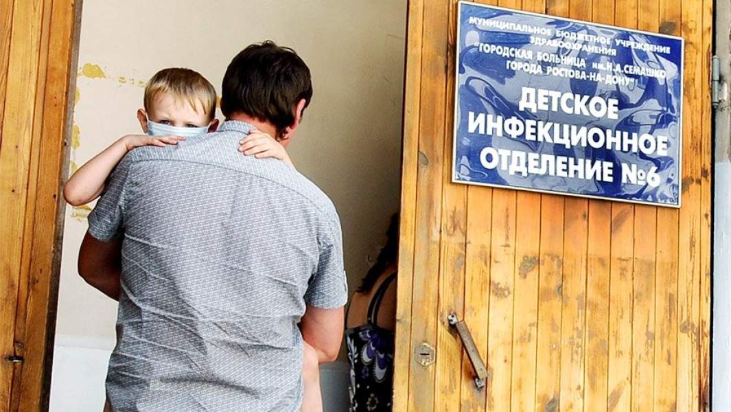 Родители с ребенком у входа в инфекционное отделение больницы