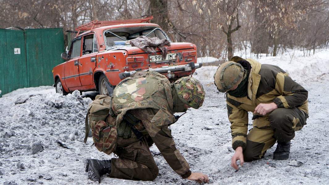 Последствия ночного обстрела — 120-миллиметровая мина в земле и разбитая гражданская машина