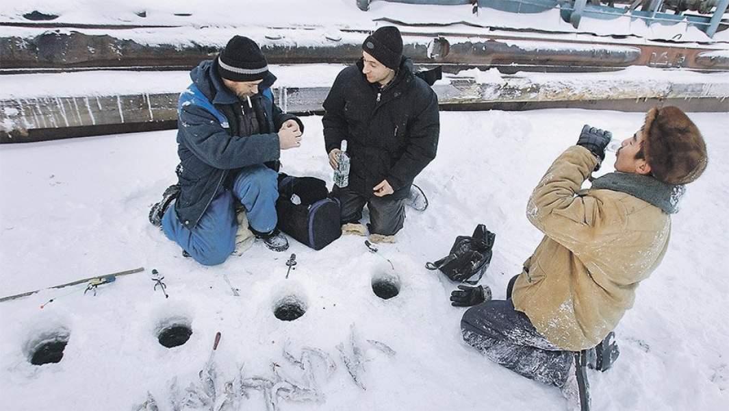 мужчины выпивают на зимней рыбалке