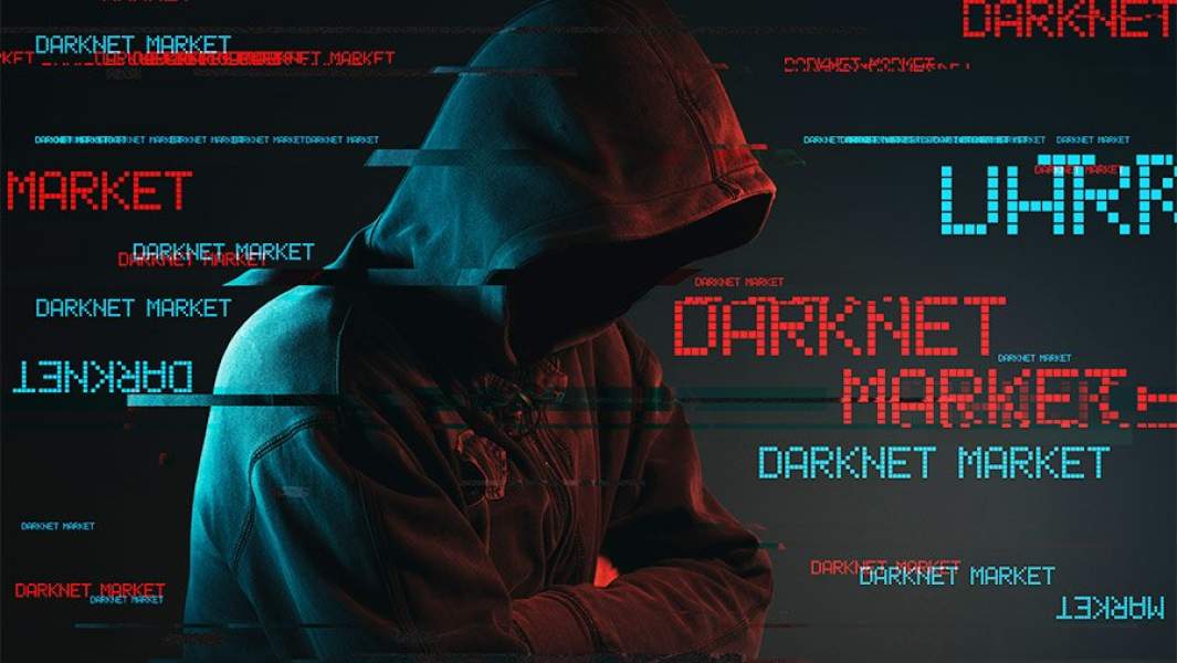 фигура в капюшоне на фоне надписей