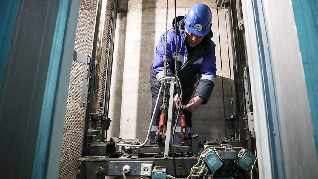 Сотрудник аварийной службы компании компании «Мослифт» во время профилактического обслуживания лифтового оборудования в одном из жилых домов