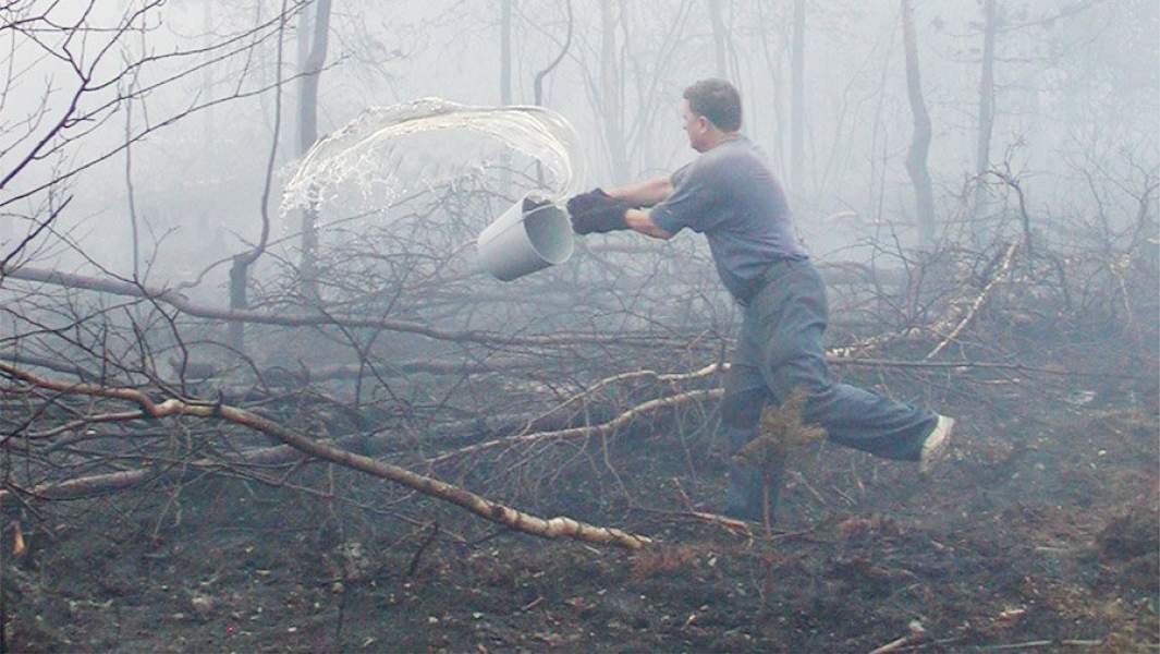 Доброволец тушит пожар водой из ведра
