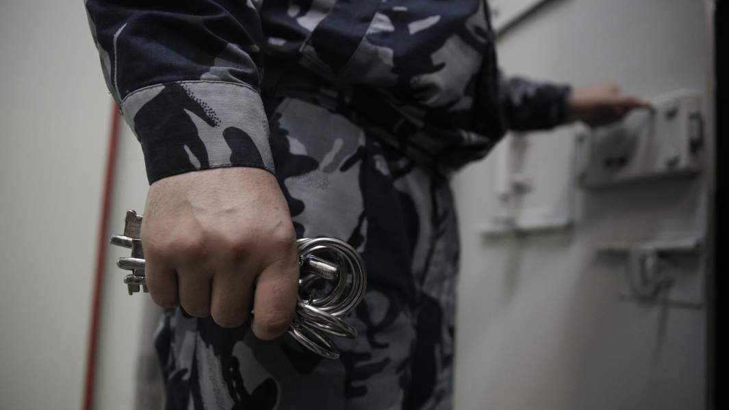 сотрудник СИЗО открывает камеру