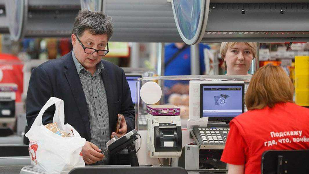 покупатель распачивается на кассе супермаркета