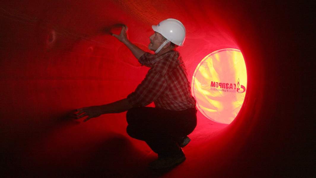 специалист осматривает трубу 