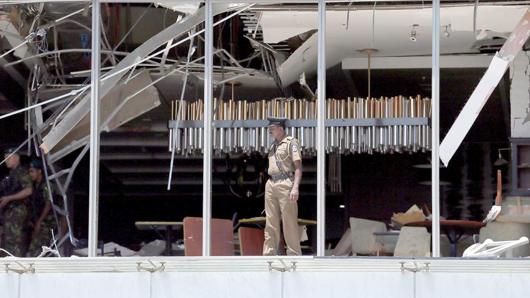 Полицейский осматривает зону взрыва в отеле Shangri-La в Коломбо, Шри-Ланка