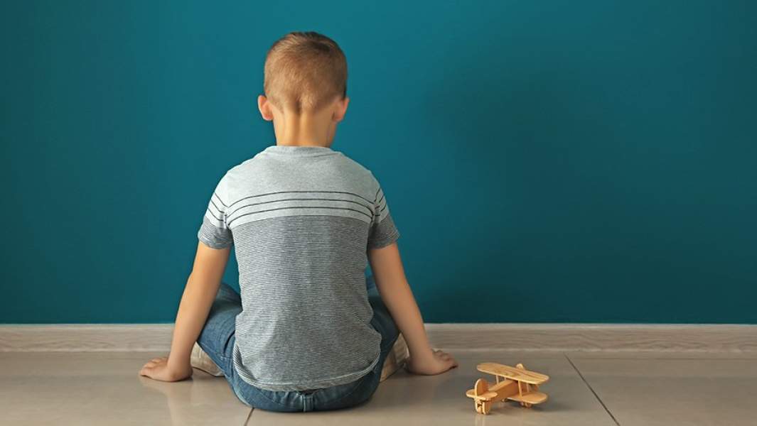 Мальчик-аутист сидит на полу