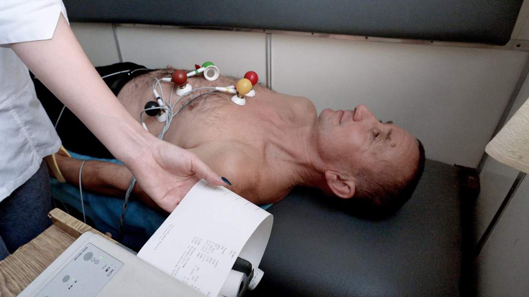 Мужчина проходит электрокардиографическое исследование в кабинете ЭКГ