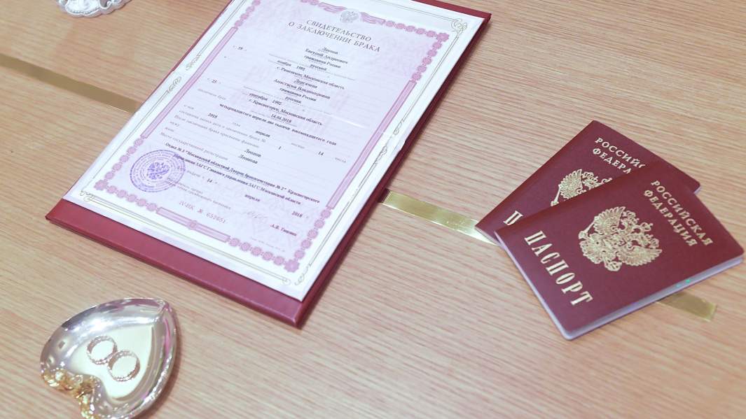 Кольца новобрачных, свидетельство о браке и паспорта молодоженов 