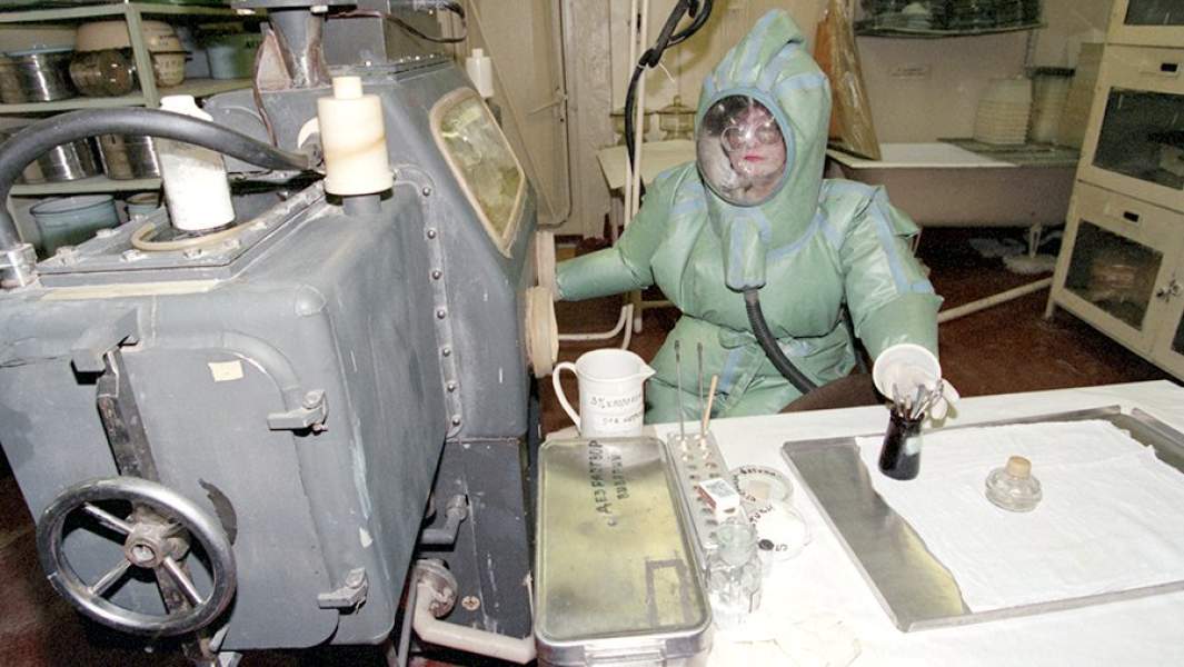 Врач медицинского учреждения работает в лаборатории в специальном защитном костюме, 1996 год