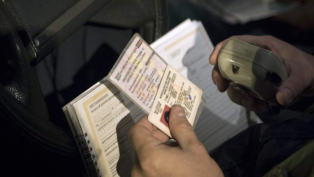 Сотрудник дорожно-патрульной службы проверяет документы во время проведения оперативно-профилактического мероприятия