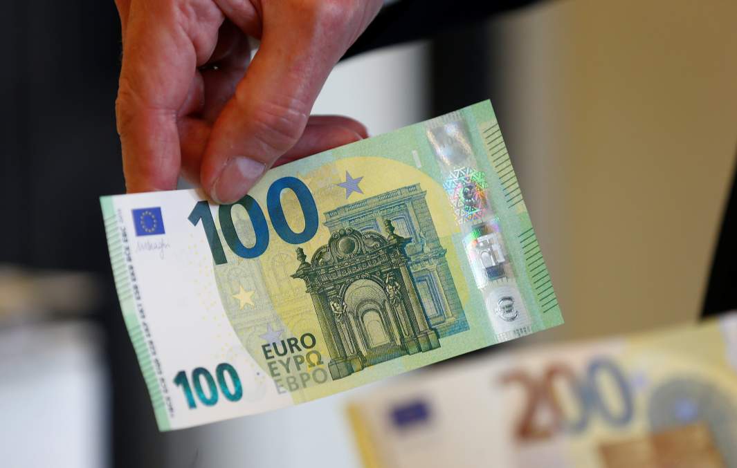 Банкноты 100 и 200 евро в руках человека