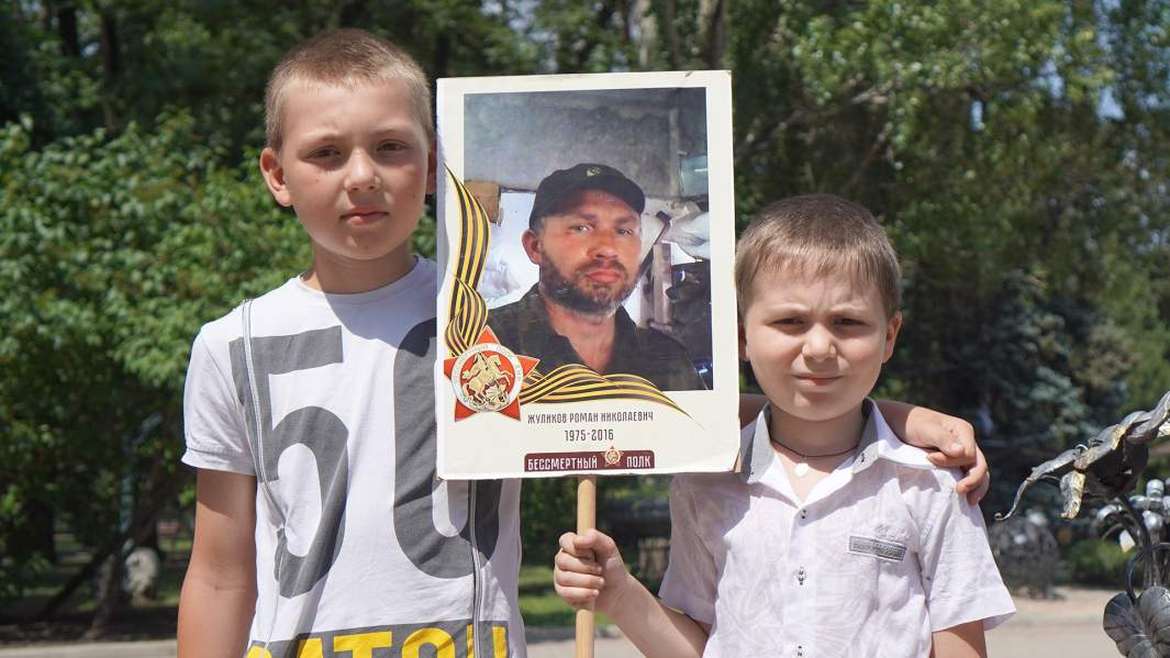 Данил и Назар Жуликовы с фотографией погибшего отца